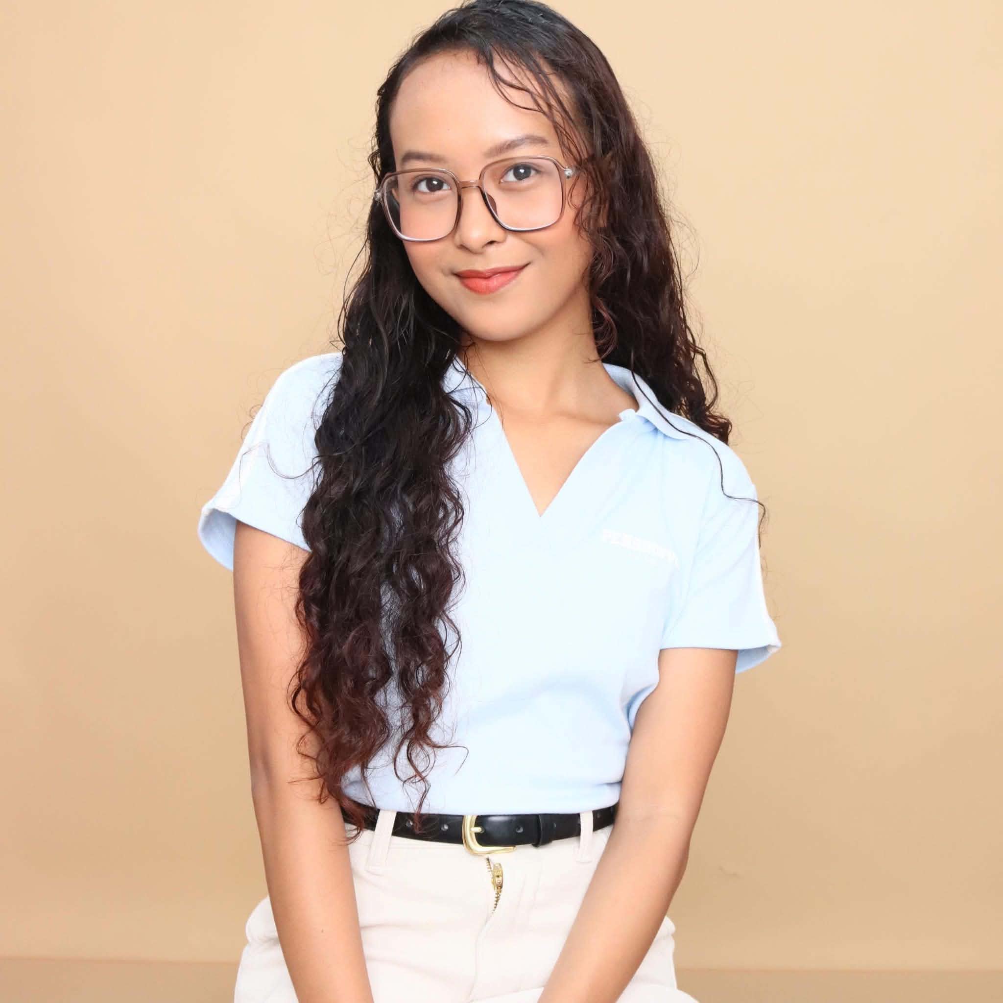 Dhaeby Joy Osita wearing glasses and a light blue blouse